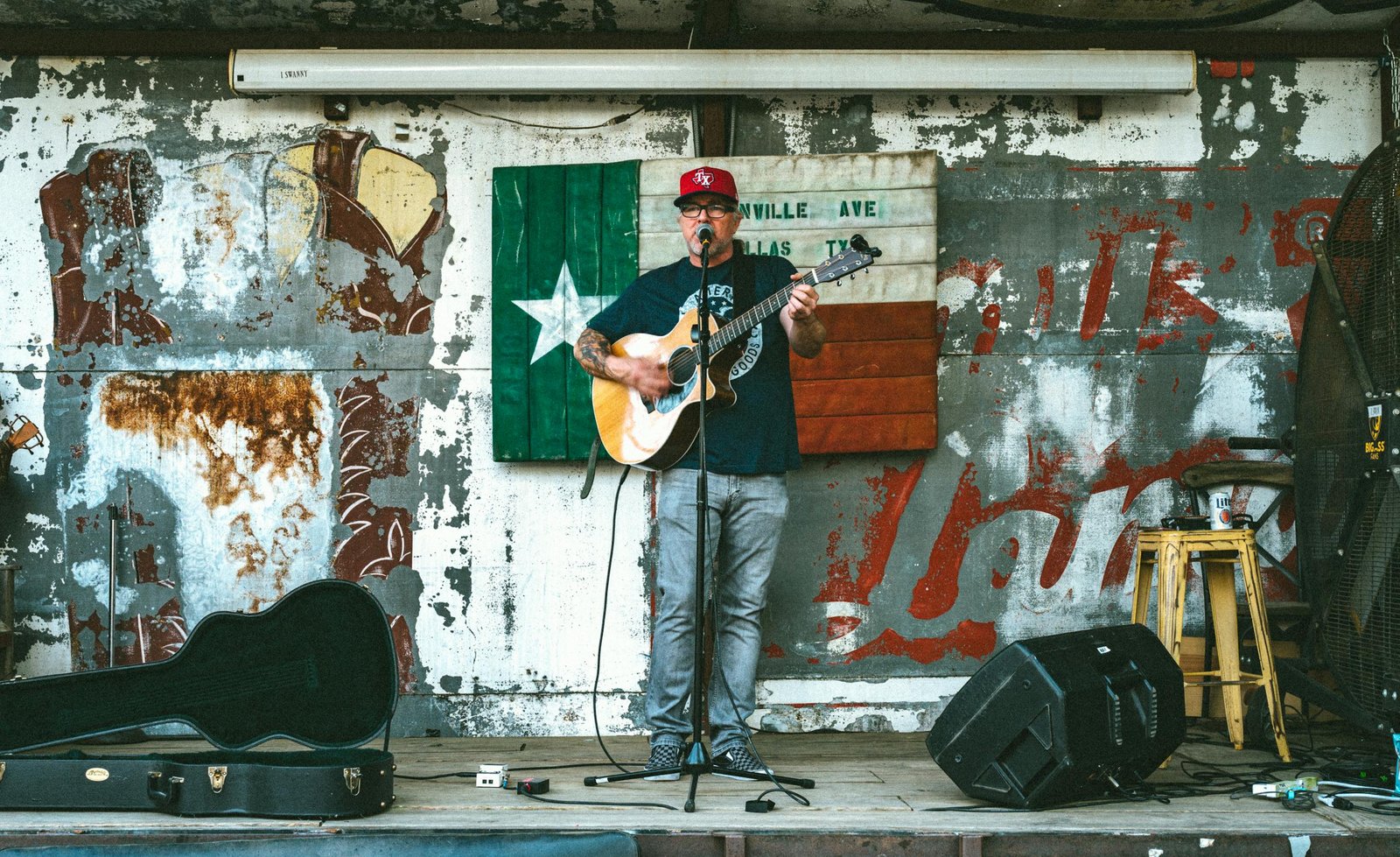 A man sings and plays guitar on a street stage in Dallas, Texas.
