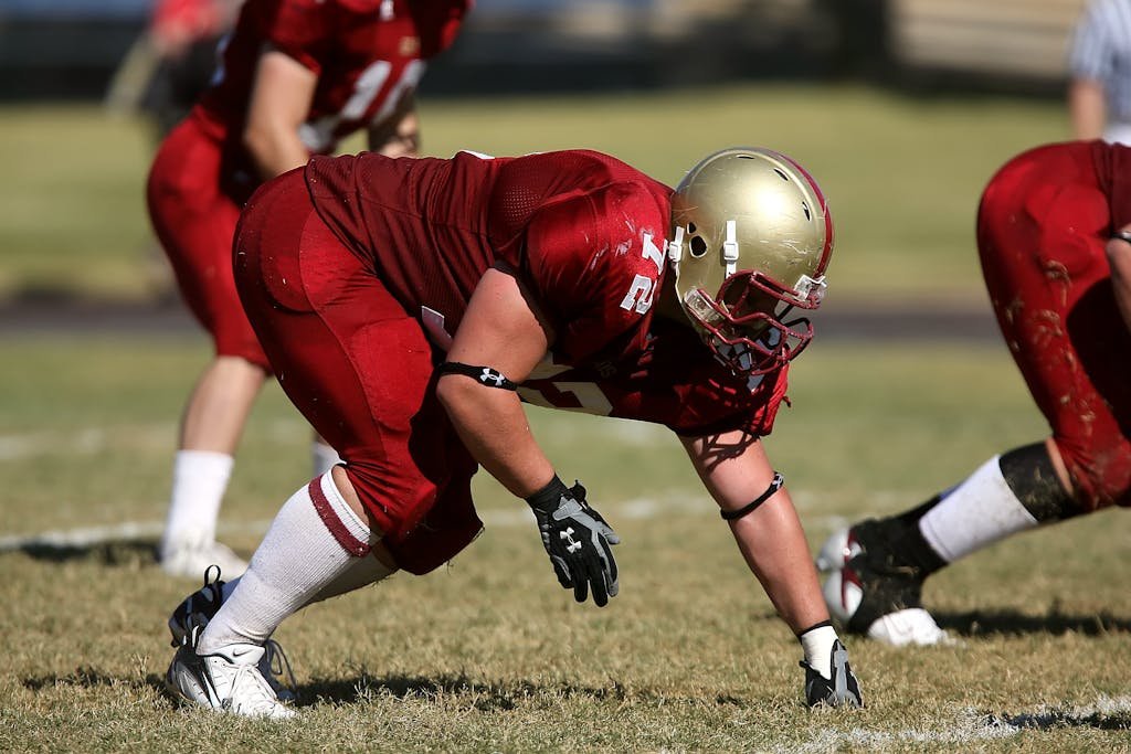 Football players ready to play on a sunny day in full uniform and helmets.